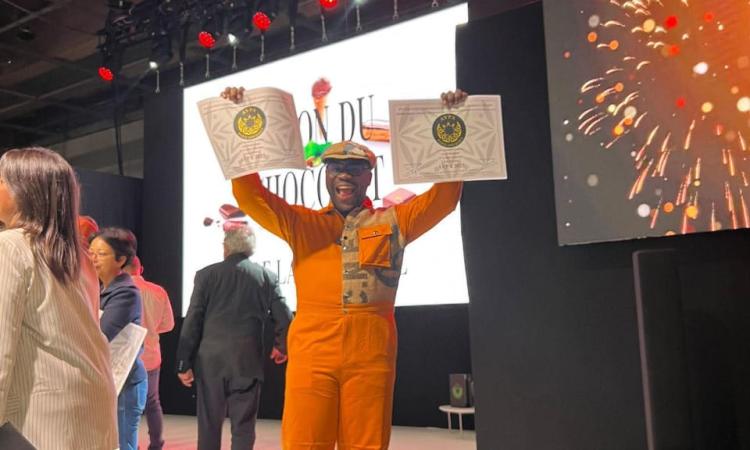 Axel Emmanuel brandissant fièrement ses deux distinctions.